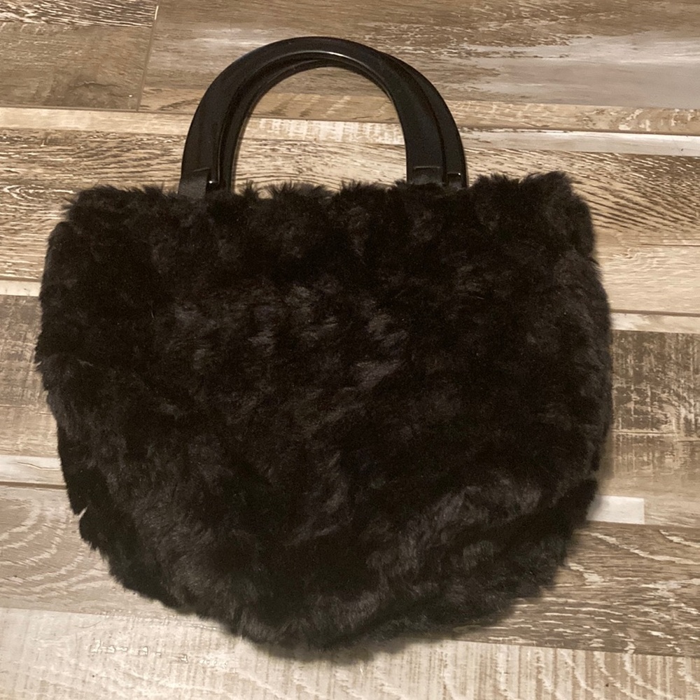 Black fuzzy purse, pink shoes fabric on the inside, solid plastic handles